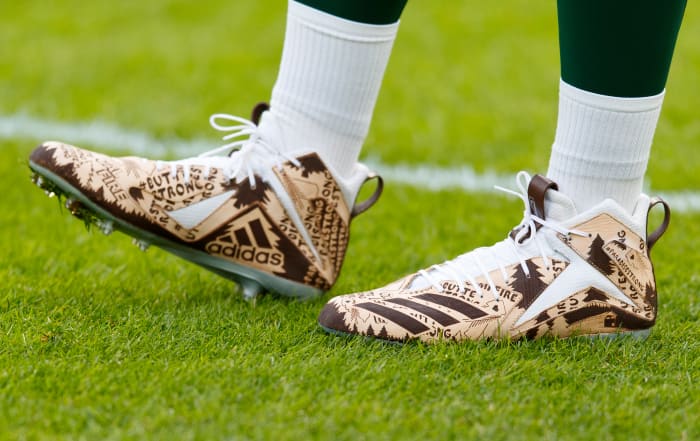 View of Aaron Rodgers' brown and white Adidas cleats.
